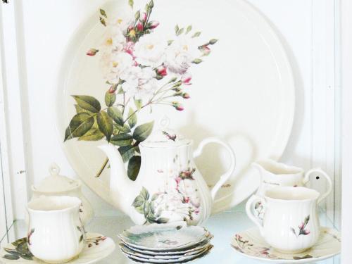 a table with a vase and cups and plates at Alkyon Villas in Sivota