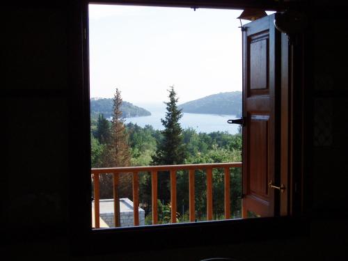 a room with a window looking out at a lake at Alkyon Villas in Sivota