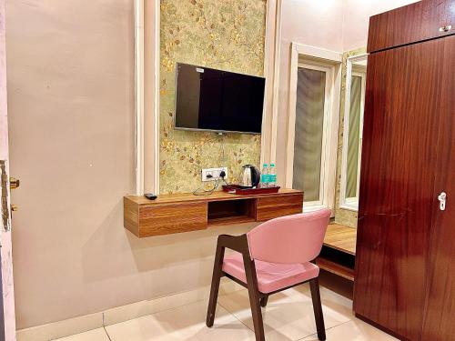 a room with a chair and a desk with a television at Siyavar Palace in Orchha