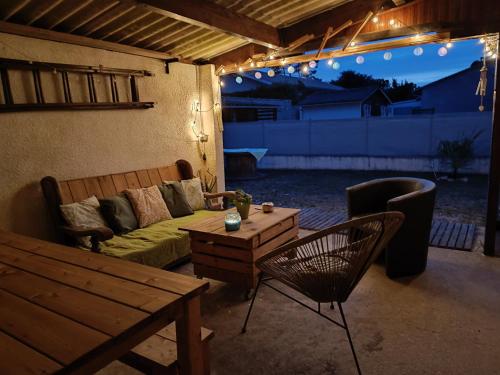 un patio avec un canapé, une table et des chaises dans l'établissement Villa Ilanga, à Soulac-sur-Mer