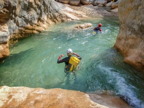 two people in the water in a river at Hotel Restaurant Les Brases in Sort