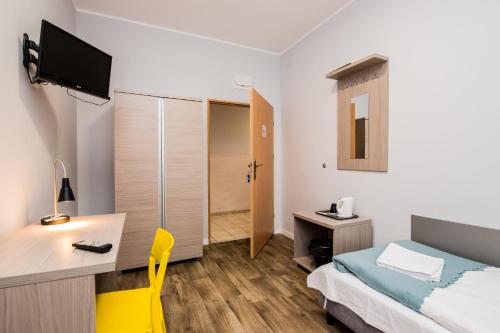 a hotel room with a bed and a desk and a television at Hotel Sportowy in Wolsztyn