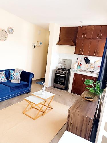 a living room with a blue couch and a table at The Place - Luxury Redefined - Kisumu in Kisumu