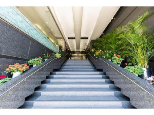 a staircase in a building with flowers and plants at Alpha Hotel Tokushima in Tokushima
