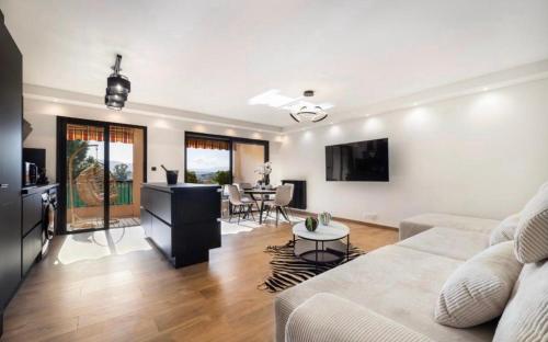 un salon avec un canapé et une table dans l'établissement Appartement haut standing - Luxury apartment - Cannes- Croisette- Centre ville- Vue Tennis -Vue Piscine -Parking privé - Terrasse- Plage, à Cannes