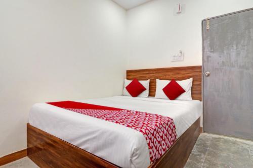 um quarto com uma cama grande com travesseiros vermelhos em Hotel O Lavish Stay em Surūrnagar