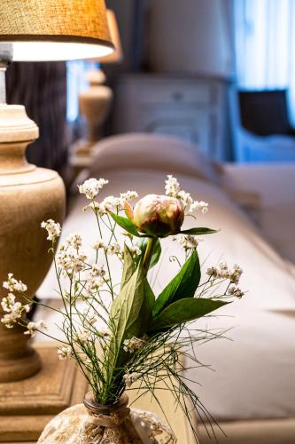 a vase filled with flowers on a table next to a bed at Casina Le Conserve in Cesenatico