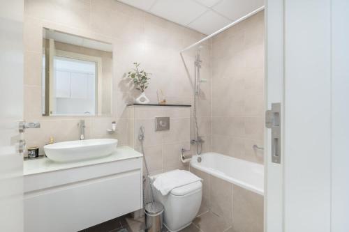 a bathroom with a sink and a toilet and a tub at Majestic Studio in Damac Carson C in Dubai Marina