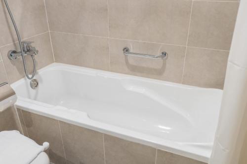 a white bath tub in a bathroom with a toilet at Majestic Studio in Damac Carson C in Dubai Marina