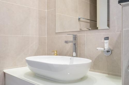 a bathroom with a white sink and a mirror at Majestic Studio in Damac Carson C in Dubai Marina