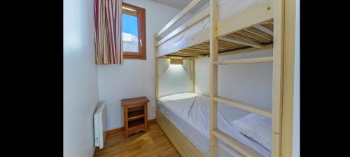 une chambre avec deux lits superposés et une fenêtre dans l'établissement Appartement les orres 1800, à Le Mélézet