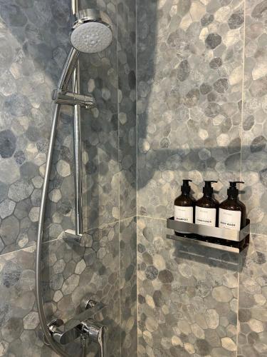 a shower with three bottles on a shelf in a bathroom at Sliema Penthouse 3 Ensuite Bedrooms Seaview - Zero55 in Sliema
