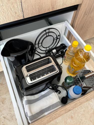 a drawer with a toaster and other kitchen utensils at Daheim in Râşnov