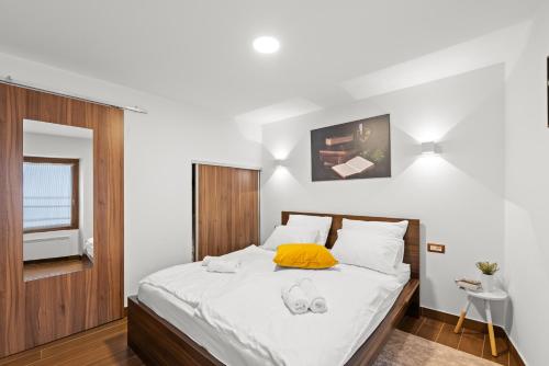 a bedroom with a large bed with a yellow pillow at NEW!!!Apartment Old Town Square in Poreč