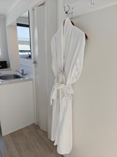 a white towel hanging on a door in a kitchen at Roselands Motel in Tauranga