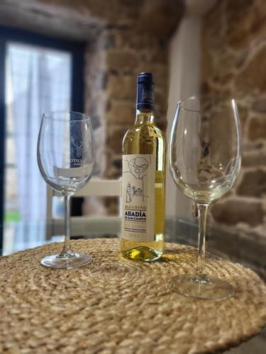 a bottle of wine and two wine glasses on a table at Casa Laxeira in Tabagón