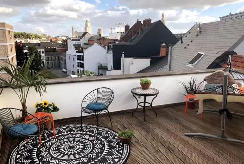a balcony with two chairs and a table on a roof at Cozy & Spacious Duplex with an Amazing Terrace in Antwerp
