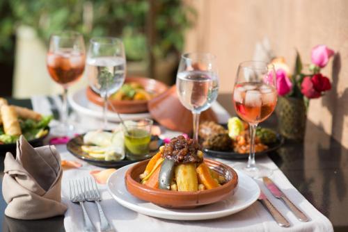 a table with plates of food and glasses of wine at Riad Dar 73 in Marrakech