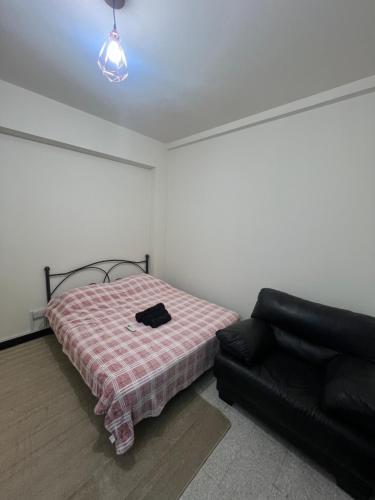 a bedroom with a bed and a black couch at Enjoy a cozy room in the heart of the capital in Nicosia