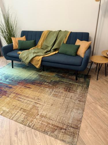 a blue couch with a blanket on top of it at Marijas Apartment with Comfort for 5 in Rīga