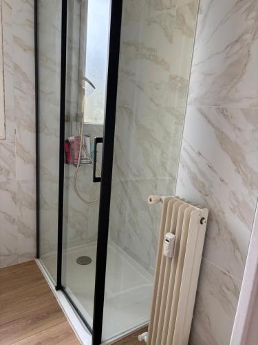 une douche avec une porte vitrée dans une salle de bain dans l'établissement Appartement 5min de la plage, à Antibes