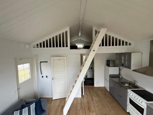 a small kitchen with a staircase in a tiny house at Suncity Solsidan in Borgholm