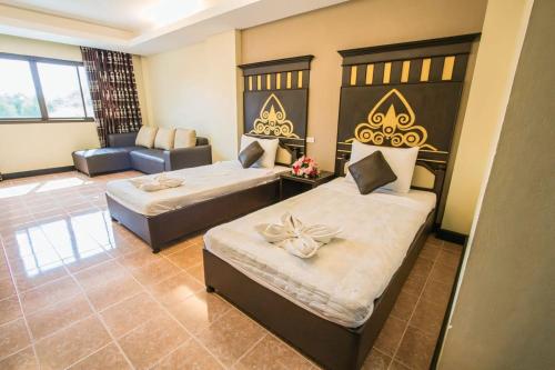a hotel room with two beds and a couch at Hoongthip hotel in Savannakhet