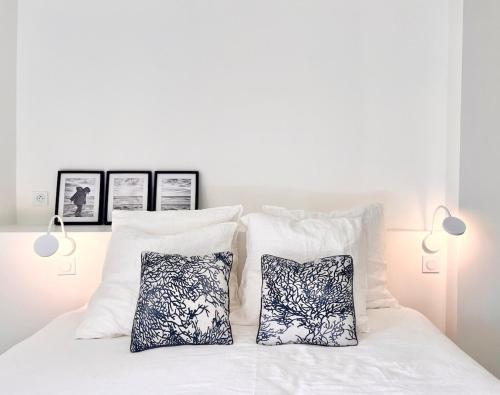 - un lit blanc avec des oreillers et 2 oreillers blancs dans l'établissement Appartement-Ocean moderne dans longère avec extérieur, à Plouhinec