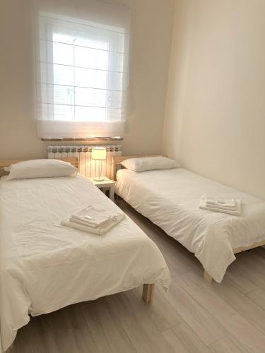two beds in a room with a window at La Villa Suite 2 in Fabriano