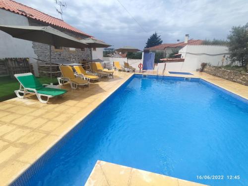 a large blue swimming pool with chairs and tables at Piscina Interior aquecida - Monte Cimeiro e Casitas da Eira - Casa da Ti Carminha in Mação