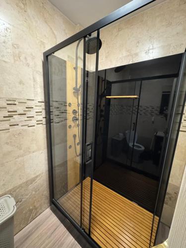 een douche met een glazen deur in een badkamer bij Apartments 1 Mamaia Nord in Mamaia Nord – Năvodari