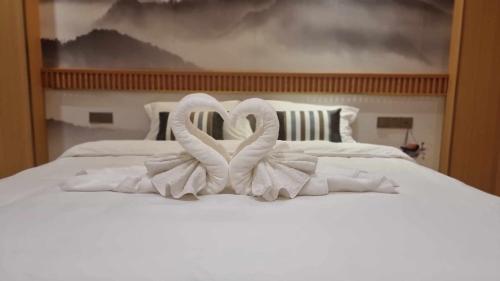 two swans making a heart on a white bed at Hoongthip hotel in Savannakhet