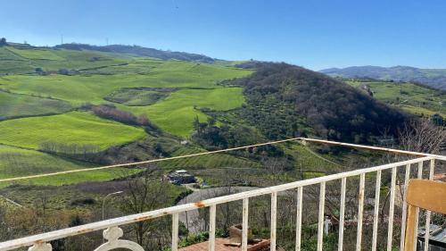 a balcony with a view of a green hill at Lupara Bella 