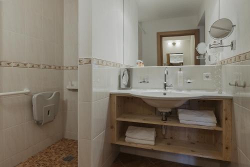 a bathroom with a sink and a mirror and a toilet at Hotel Marten - Ski-In & Ski-Out in Saalbach Hinterglemm