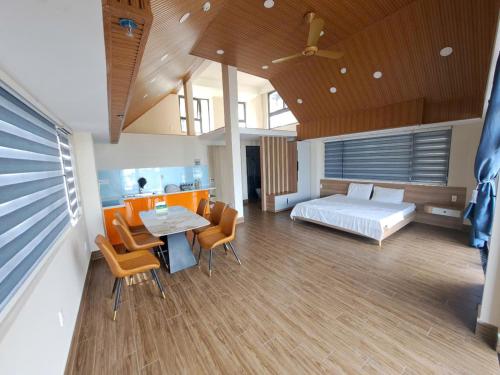 a bedroom with a bed and a table and chairs at Khách Sạn The Pine Scent in Da Lat