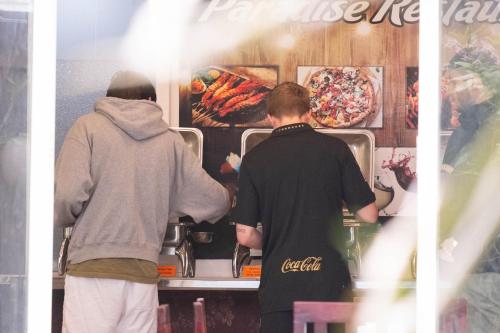 Zwei Personen bereiten Essen in einem Imbisswagen zu. in der Unterkunft Paradise Hotel Hoi An in Hoi An