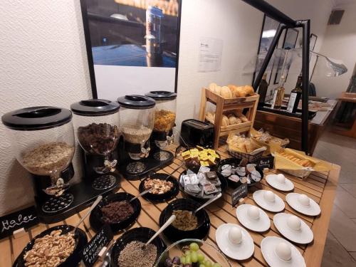 a table topped with bowls and plates of food at Hotel Thesdorfer Hof in Pinneberg