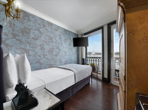 a hotel room with a bed and a balcony at Movenpick SS Misr Steamer Nile Cruise - 04 & 07 Nights Each Monday From Luxor and 03 Nights Each Friday from Aswan in Luxor