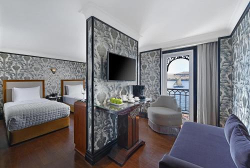 a hotel room with a bedroom with a bed and a tv at Movenpick SS Misr Steamer Nile Cruise - 04 & 07 Nights Each Monday From Luxor and 03 Nights Each Friday from Aswan in Luxor