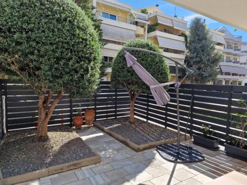 a patio with two trees and a fence at Dantis Place in Nafplio wheel chair accessible in Nafplio