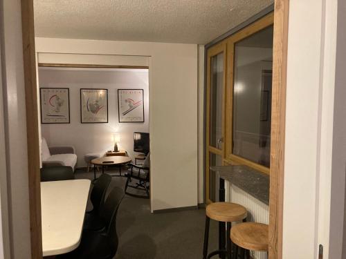 Cette chambre comprend un salon avec une table et des chaises. dans l'établissement Appartement 4 pièces - 8 personnes - Résidence le France, à La Plagne Tarentaise