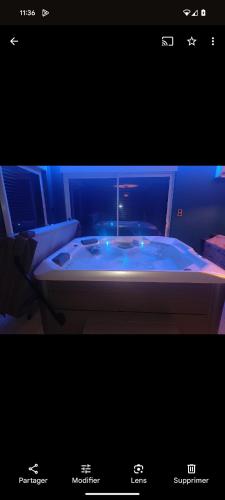 La salle de bains est pourvue d'une baignoire avec des lumières bleues. dans l'établissement Ô bonheur du paon, à Arques