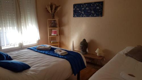 Un dormitorio con una cama con toallas. en Le Petit HERMITAGE - Gite 4 pers, en Massiac