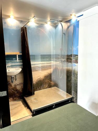 La salle de bains est pourvue d'une douche et offre une vue sur la plage. dans l'établissement Le Loft centre Paramé avec coin extérieur, à Saint-Malo
