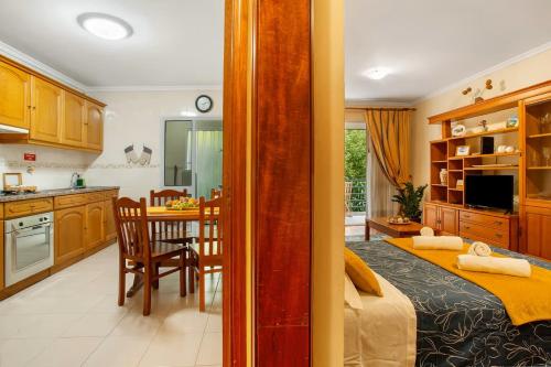 a kitchen and living room with a bed and a table at Madeira Funchal Gardens in Funchal