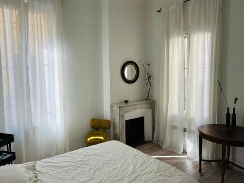une chambre blanche avec un lit et une cheminée dans l'établissement Charmante 3 Zimmer, Stadtwohnung, à Menton
