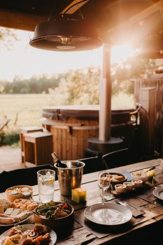 a wooden table with plates of food on it at KARIBU - Olifant in Kasterlee