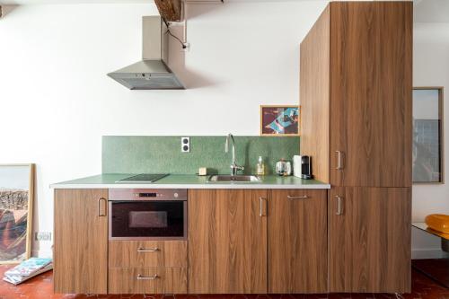 une cuisine avec des armoires en bois et un évier dans l'établissement Superbe appartement au cœur du Panier - Vieux-Port, à Marseille