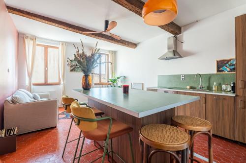 une cuisine avec un grand îlot et des tabourets dans l'établissement Superbe appartement au cœur du Panier - Vieux-Port, à Marseille