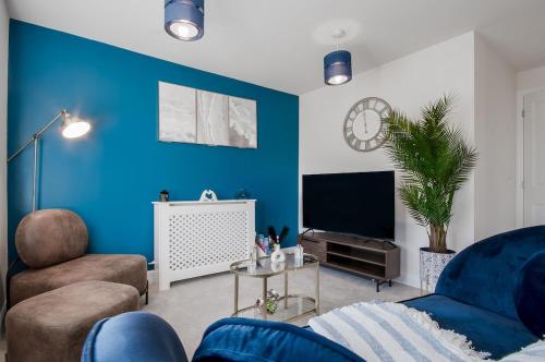 a living room with blue walls and a tv at Cozy 2 Bed in Milton Keynes Free parking & WiFi in Milton Keynes